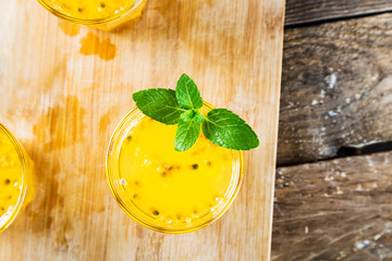 Top view of passion fruit drinks with mint on wooden table