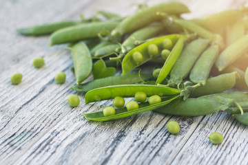 Green pea on wooden table in sunlight.