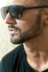 Portrait of a man sideways. Beard and sunglasses. Stylish guy. Beautiful male face close up. Beard and confident look.
