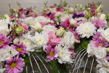 Various bridal flower heads in vintage ornate bird cage as bloom decoration at a wedding reception