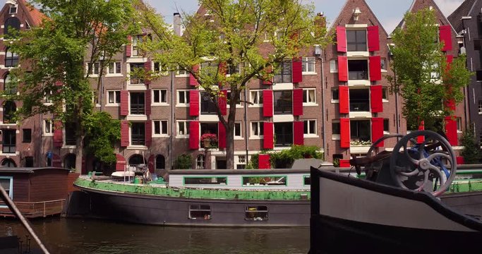 Beautiful typical Amsterdam canal houses with red wooden window hatches