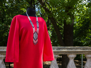 Red dress on mannequin. Autumn women's dress with long sleeves. Women's clothing straight cut on...