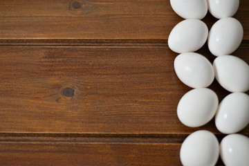 white eggs on wooden plate on wooden background , copy space 