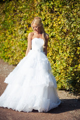 Fototapeta na wymiar Beautiful blonde bride in fashion white wedding dress