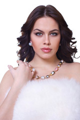 Portrait of a young beautiful brunette girl in a white fur collarover