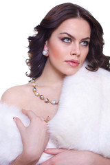 Portrait of a young beautiful brunette girl in a white fur collarover