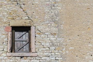 Fototapeta na wymiar Ancient brick wall with old wooden window shutters