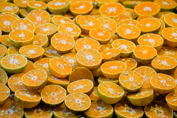 Many bright juicy orange fruits slices, cuts, halves,Orange color background.