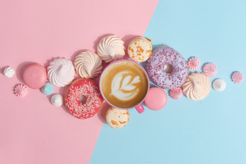 Kitchen utensils and tools, pastries and sweets on a pink and blue background. Top view. Copy space.