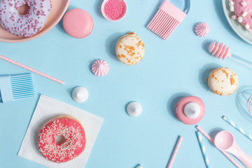 Kitchen utensils and tools, pastries and sweets on blue background. Top view. Copy space.