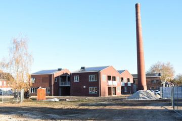 nieuwe woningen op een oud fabrieksterrein met oude schoorsteenpijp