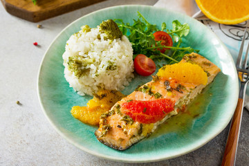Grilled Salmon with Grapefruit and Orange Sauce and rice garnish on a light stone or concrete table.
