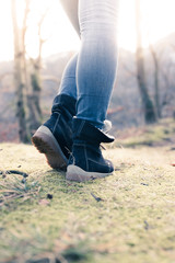Fototapeta premium Boots of a young woman, cutout, outdoors in timberland, autumn