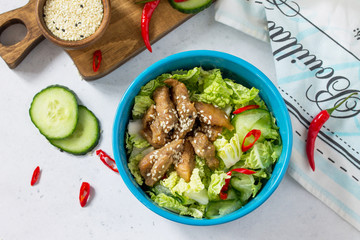 Diet menu. Healthy salad with Chinese cabbage, chicken, sesame and chili pepper on a white stone background. Copy space.