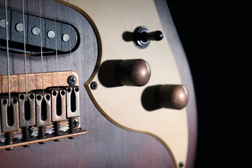 Modern electric guitar in darkness, closeup view