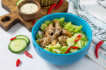 Diet menu. Healthy salad with Chinese cabbage, chicken, sesame and chili pepper on a white stone background.