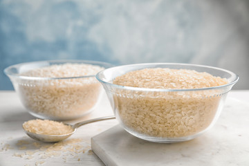 Bowl with uncooked rice on kitchen table