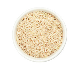 Bowl with raw unpolished rice on white background, top view