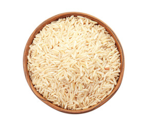 Bowl with raw unpolished rice on white background, top view