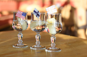 Glass of friut spirits with peaces of pears on a wooden table.