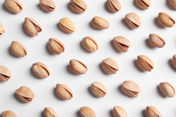 Organic pistachio nuts on white background, flat lay