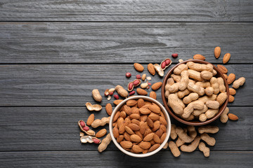 Flat lay composition with organic nuts and space for text on wooden background, top view. Snack mix
