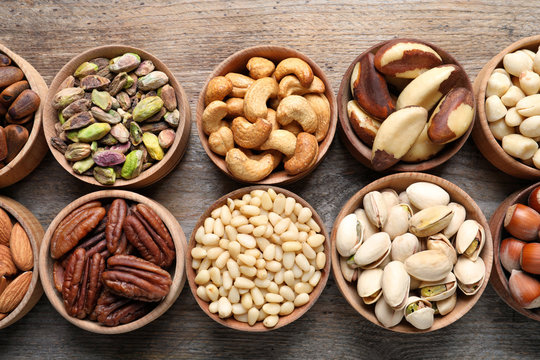 Flat lay composition with organic nuts on wooden background, top view. Snack mix