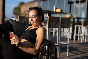 Young woman enjoys mobile phone in a bar
