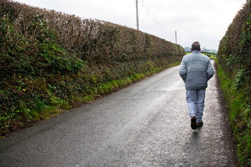 man walking on country road of wales uk