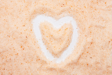 Himalayan salt, heart-shaped, isolated, close up, macro, top view. Flavor food spice pinkish tint....
