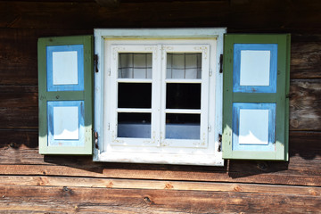 blue destroyed window in a rustic wooden cottage in the open-air museum