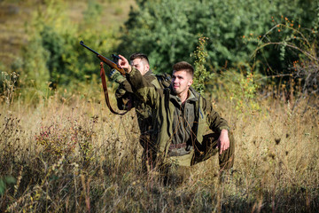 Hunter friend enjoy leisure in field. Hunters gamekeepers looking for animal or bird. Hunting with...