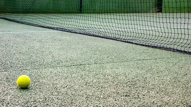 PELOTA DE PADEL EN EL SUELO DE LA PISTA JUNTO A RED