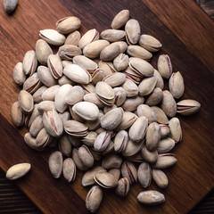 Delicious salted pistachios  on wooden background