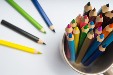 Set of colorful wooden pencils in cup on white background