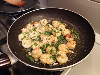 Cooking shrimps with butter in a black pan