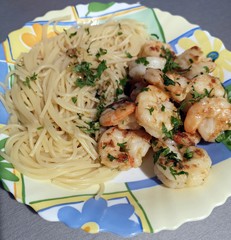 Fried shrimps with butter, parsley served with spaghetti