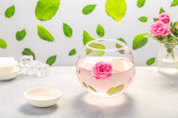 Facial lotion extract with rose petals. Cotton pads. Healing homemade skincare moisture tonic.