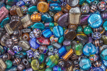 Fototapeta na wymiar multi-colored glass gems with holes lie in a heap