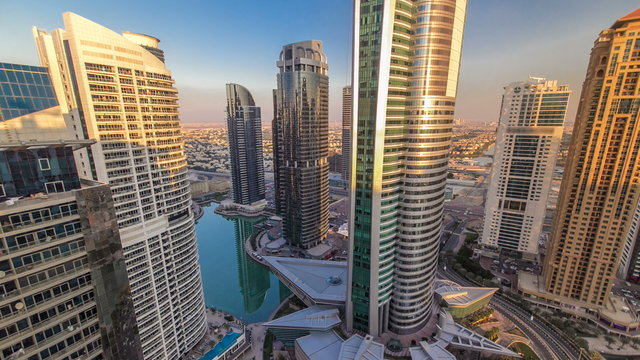 Top view of buildings Jumeirah Lakes Towers with traffic on the road sunset timelapse.