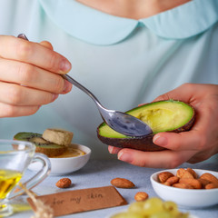 Brunette tasting avocado and almond health products fro her skin note