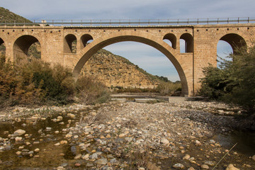 Fototapeta na wymiar old stone bridge across the river, province of almeria, region of andalucia, spain