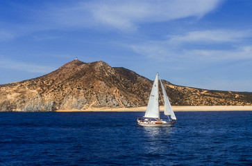 sailboat offshore of cab san lucas old lighthouse
