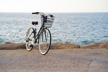 Fototapeta premium Bicycle parked on beach. Retro bike near the sea. Bike on the background of the sea horizon. 