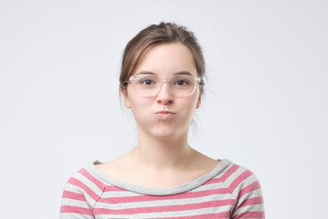 Cute pretty woman blowing her cheeks with pleasure having fun.