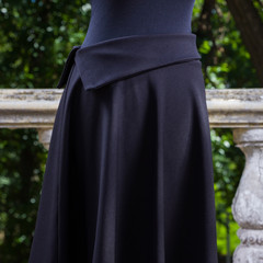 Black skirt on mannequin. Skirt straight cut on background of green trees. Women's skirt in black...