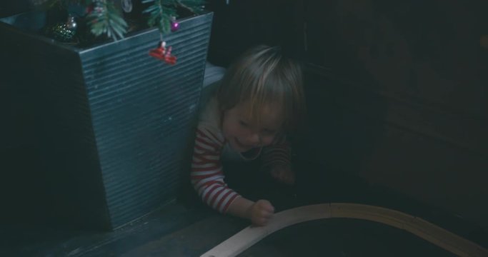 Little toddler crawling around under christmas tree