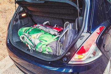 Car trunk with backpacks and luggage. Travel and hiking concept © EdNurg