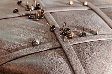 Furniture decorative nails on the background of fabric upholstery