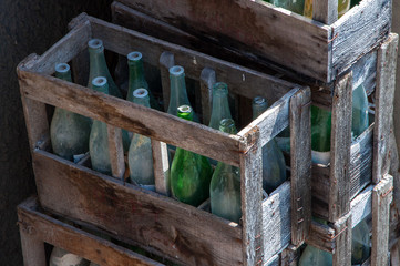 Cajas de madera apiladas con botellas antiguas